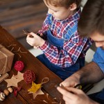 Vater und Sohn basteln zusammen Weihnachtssterne